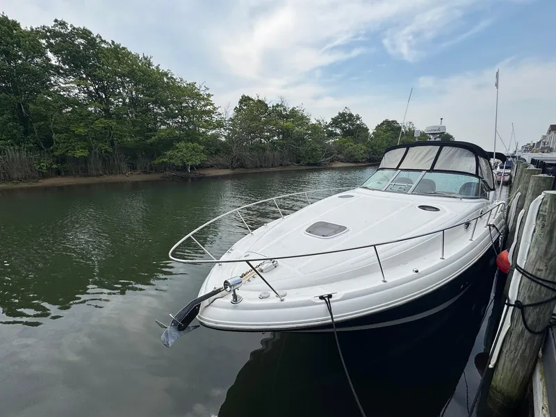 Slide: The Image of 2003 Sea Ray 340 Sundancer docked on a calm river with lush greenery. - 3