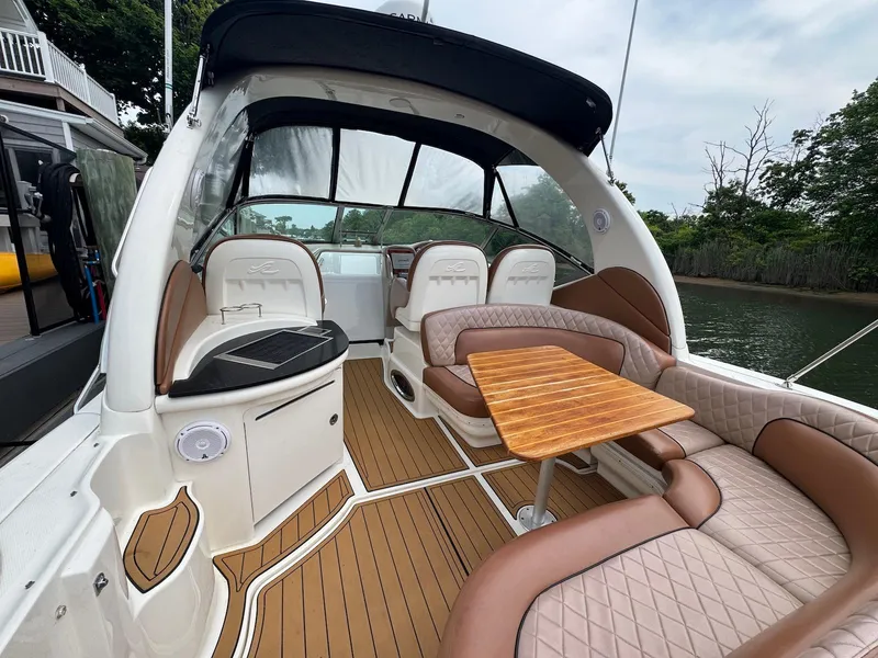 Slide: The Image of 2003 Sea Ray 340 Sundancer interior with elegant seating and wooden table on deck. - 6