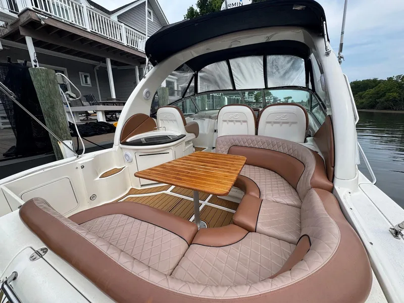 Slide: The Image of 2003 Sea Ray 340 Sundancer boat with elegant seating and wooden table on deck. - 7