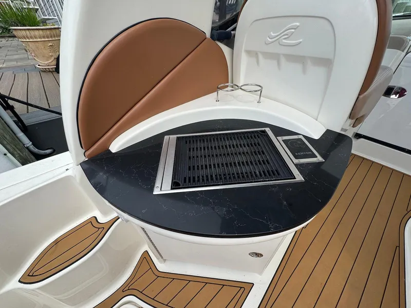 Slide: The Image of 2003 Sea Ray 340 Sundancer boat interior with grill and seating area. - 9