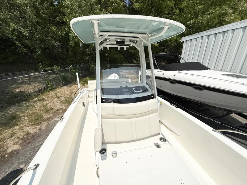 Slide: The Image of 2022 Boston Whaler 220 Dauntless boat with T-top, parked outdoors. - 12