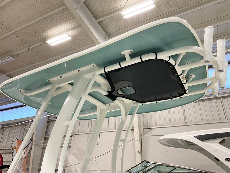 Slide: The Image of 2022 Boston Whaler 220 Dauntless T-top structure in a showroom setting. - 17
