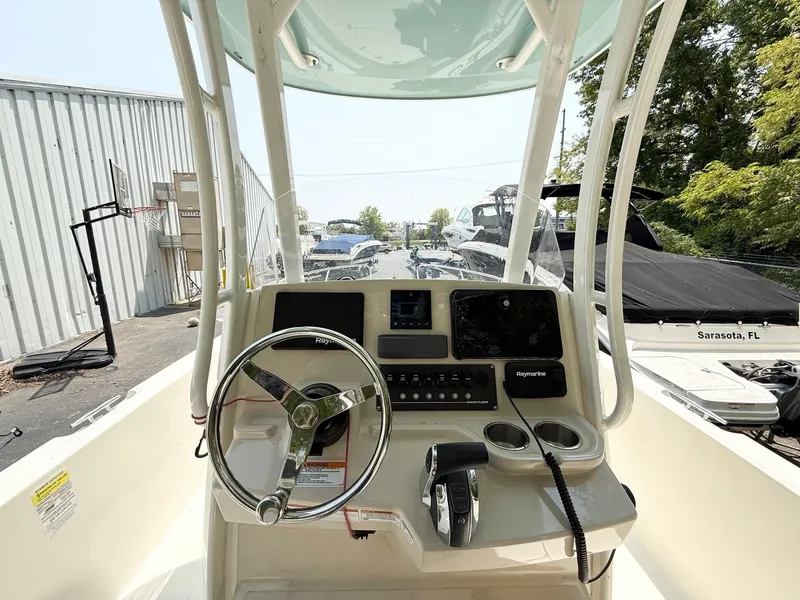 Slide: The Image of 2022 Boston Whaler 220 Dauntless boat console with steering wheel and controls. - 9