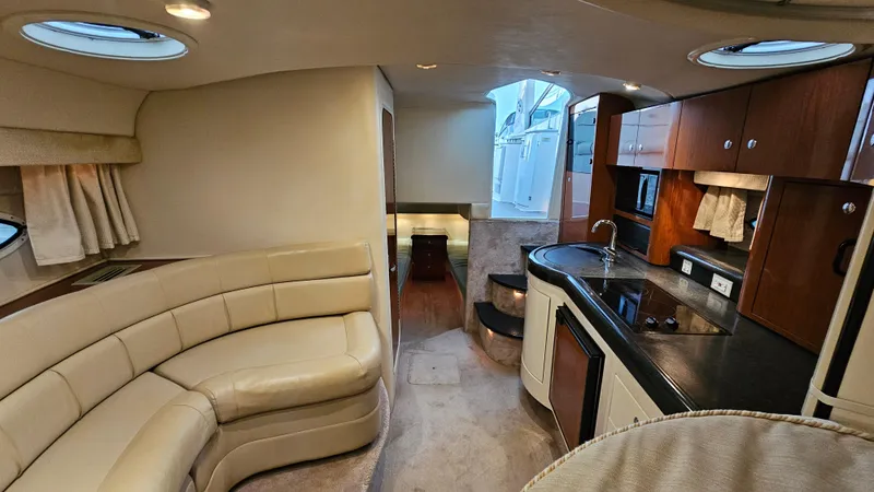 Slide: The Image of Interior of a 2003 Monterey 322 Cruiser with beige seating and modern kitchen amenities. - 18