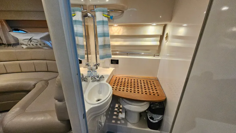 Slide: The Image of Interior of 2003 Monterey 322 Cruiser bathroom with sink, toilet, and wooden shower mat. - 21