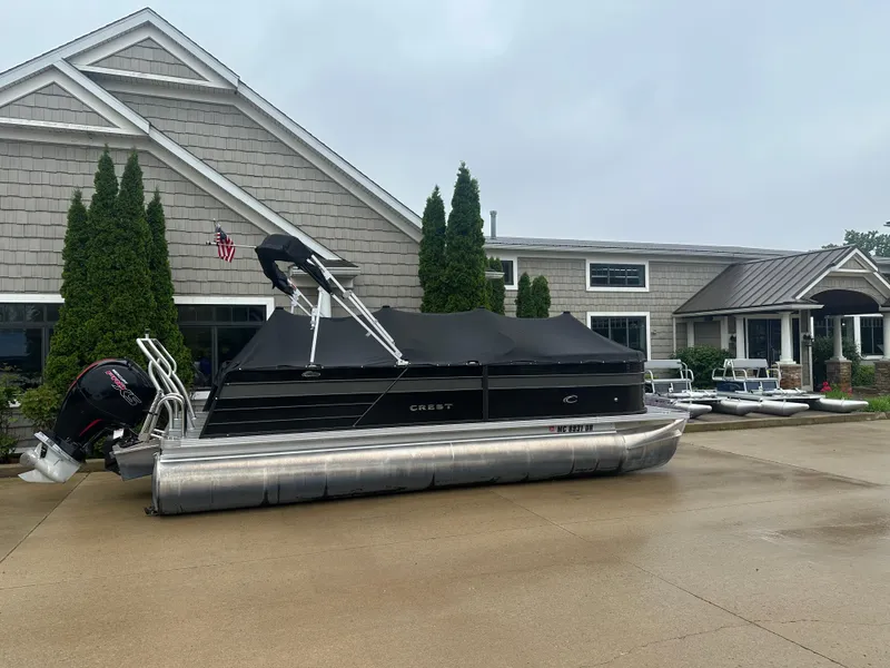Slide: The Image of 2022 Crest Classic DLX SLRC 220 pontoon boat parked outside a building. - 1