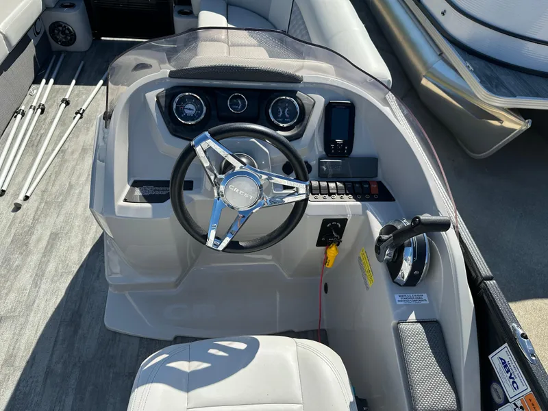 Slide: The Image of 2022 Crest Classic DLX SLRC 220 boat dashboard with steering wheel and controls. - 11