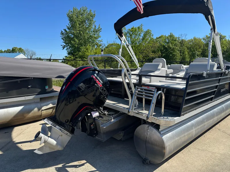 Slide: The Image of 2022 Crest Classic DLX SLRC 220 pontoon boat with outboard motor, docked outdoors. - 2