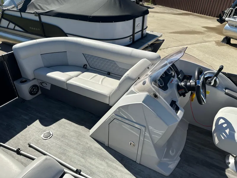 Slide: The Image of 2022 Crest Classic DLX SLRC 220 pontoon boat interior with helm and seating area. - 6