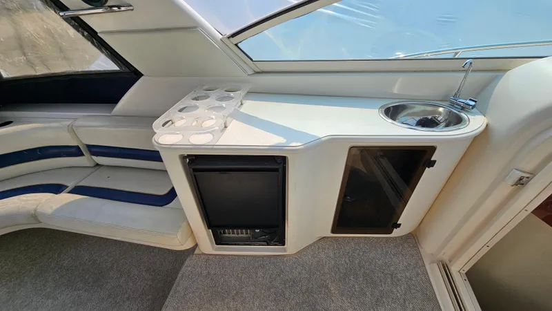 Slide: The Image of 1997 Donzi 3250 LXC boat interior with kitchenette, sink, and seating area. - 10