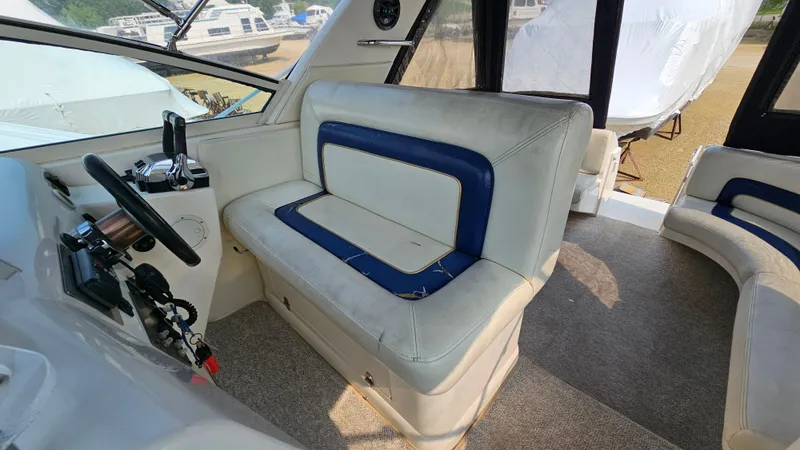 Slide: The Image of 1997 Donzi 3250 LXC boat interior with white and blue seating, steering controls visible. - 11
