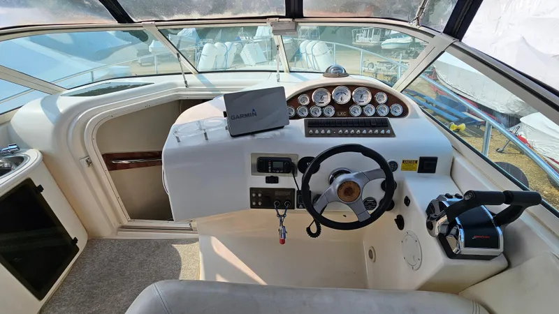 Slide: The Image of 1997 Donzi 3250 LXC boat cockpit with steering wheel, gauges, and Garmin device. - 12