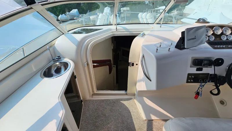 Slide: The Image of 1997 Donzi 3250 LXC boat interior with helm, sink, and cabin entrance. - 13