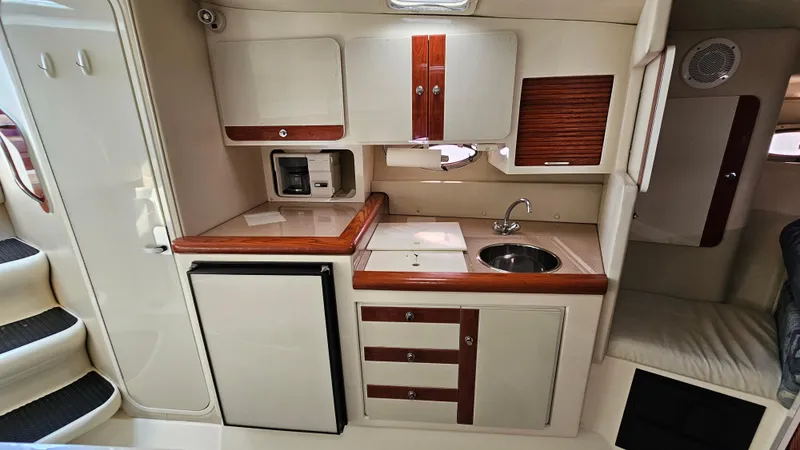 Slide: The Image of 1997 Donzi 3250 LXC boat interior kitchen with sink, fridge, and cabinets. - 18