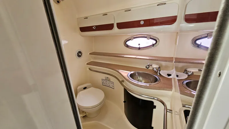 Slide: The Image of 1997 Donzi 3250 LXC boat bathroom with sink, toilet, and storage cabinets. - 22