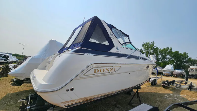 Slide: The Image of 1997 Donzi 3250 LXC boat on trailer, featuring sleek design and navy canopy. - 4