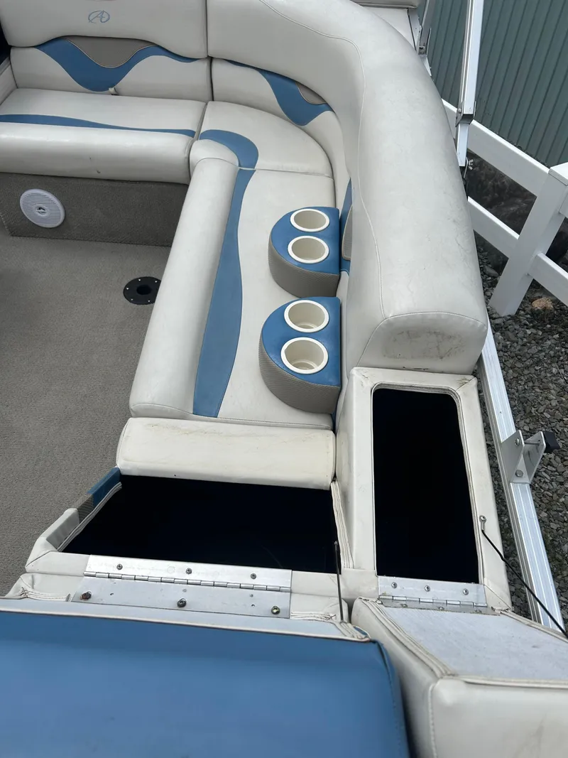 Slide: The Image of 2007 Avalon Windjammer boat interior with cushioned seating and cup holders. - 23