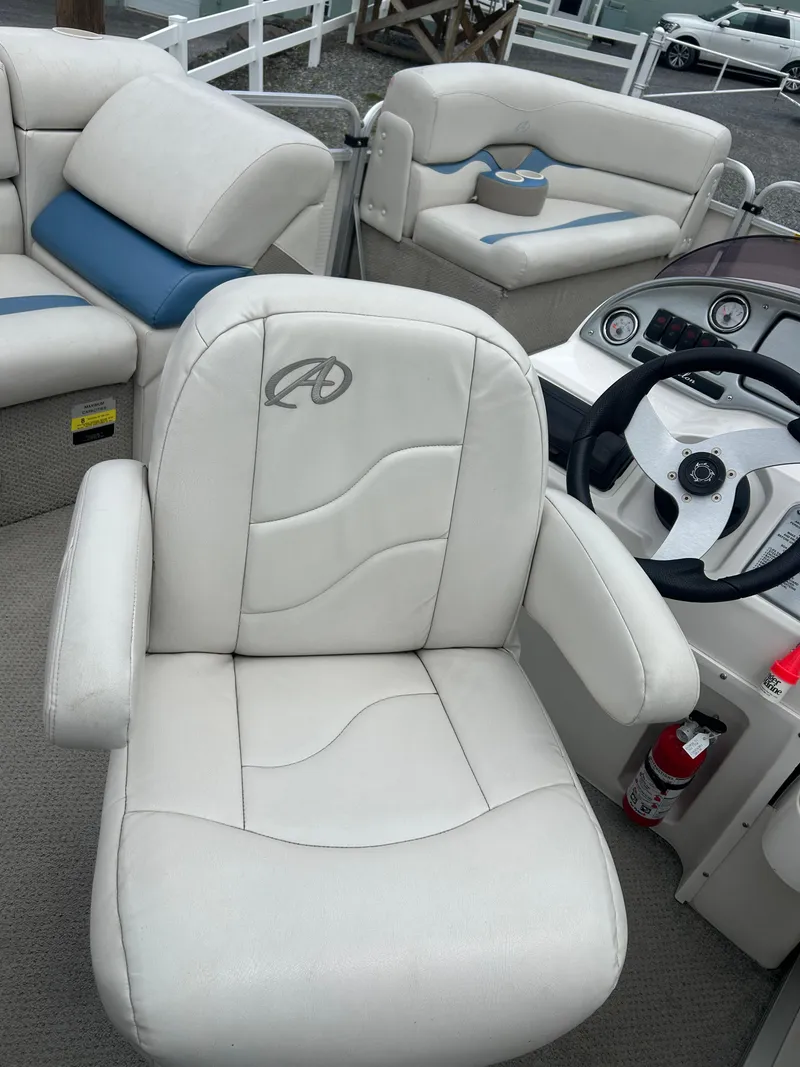 Slide: The Image of 2007 Avalon Windjammer boat interior with white seating and steering console. - 25