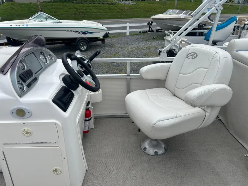 Slide: The Image of 2007 Avalon Windjammer boat interior with white captain's chair and steering console. - 28