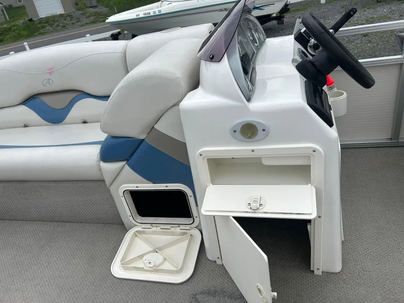 Slide: The Image of 2007 Avalon Windjammer 18' boat interior with steering console and storage compartments. - 29