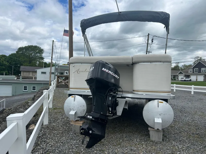 Slide: The Image of 2007 Avalon Windjammer 18' pontoon boat with Mercury outboard motor on gravel lot. - 9