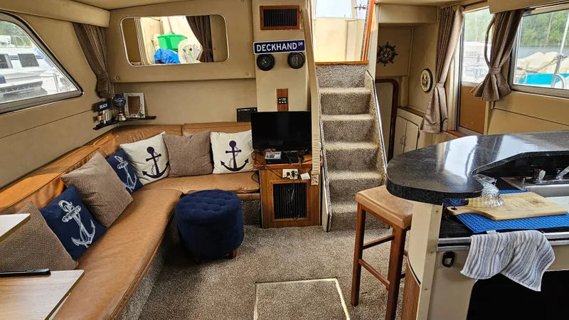 Slide: The Image of 1986 Chris-Craft 381 Catalina interior with cozy seating, nautical decor, and modern amenities. - 11