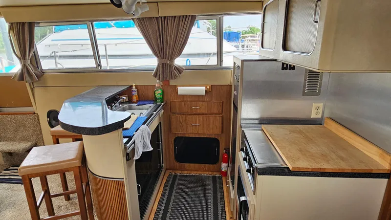 Slide: The Image of Interior of 1986 Chris-Craft 381 Catalina yacht with kitchen and seating area. - 14