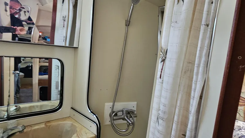 Slide: The Image of 1986 Chris-Craft 381 Catalina bathroom with shower, sink, and mirrored cabinet. - 17