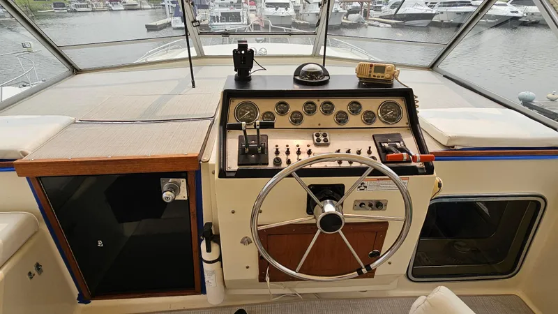 Slide: The Image of 1986 Chris-Craft 381 Catalina helm with steering wheel and control panel, docked at marina. - 7