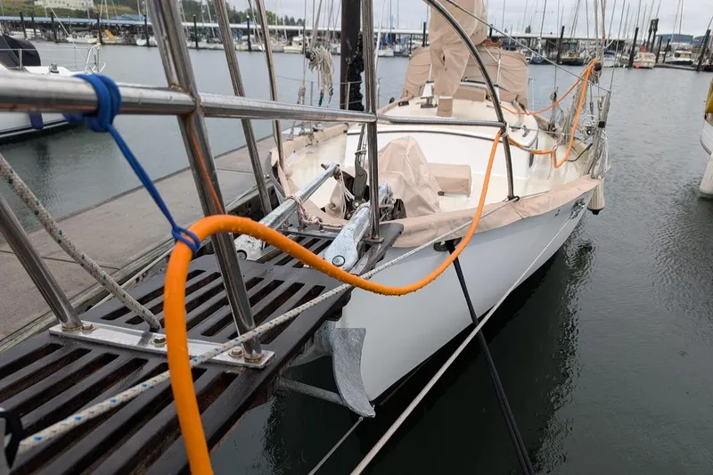 Slide: The Image of 1977 Alajuela 38 Mk1 sailboat docked in a marina, featuring a covered deck. - 16
