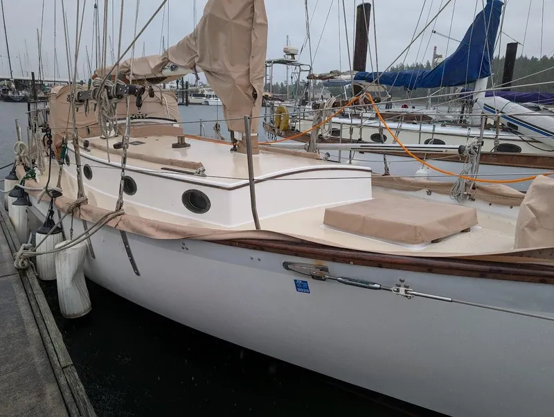 Slide: The Image of 1977 Alajuela 38 Mk1 sailboat docked at marina, covered in beige tarps. - 2