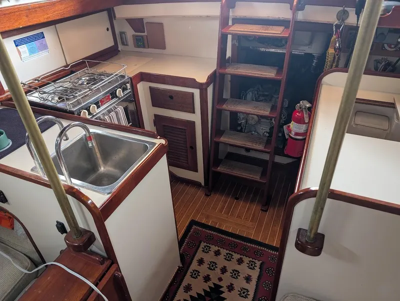 Slide: The Image of Interior of 1977 Alajuela 38 Mk1 sailboat with kitchen, sink, stove, and wooden ladder. - 27
