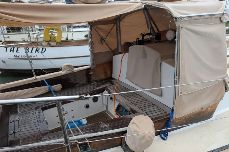 Slide: The Image of 1977 Alajuela 38 Mk1 sailboat with beige canopy and wooden deck in marina. - 9