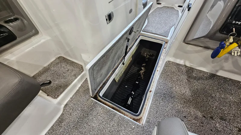 Slide: The Image of 2011 Yamaha Boats 242 Limited S interior storage compartment with carpeted flooring and keys. - 20