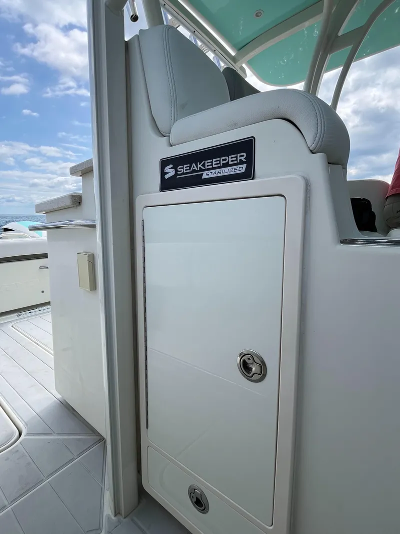 Slide: The Image of 2019 HCB Siesta boat interior with Seakeeper system, featuring sleek seating and storage. - 19