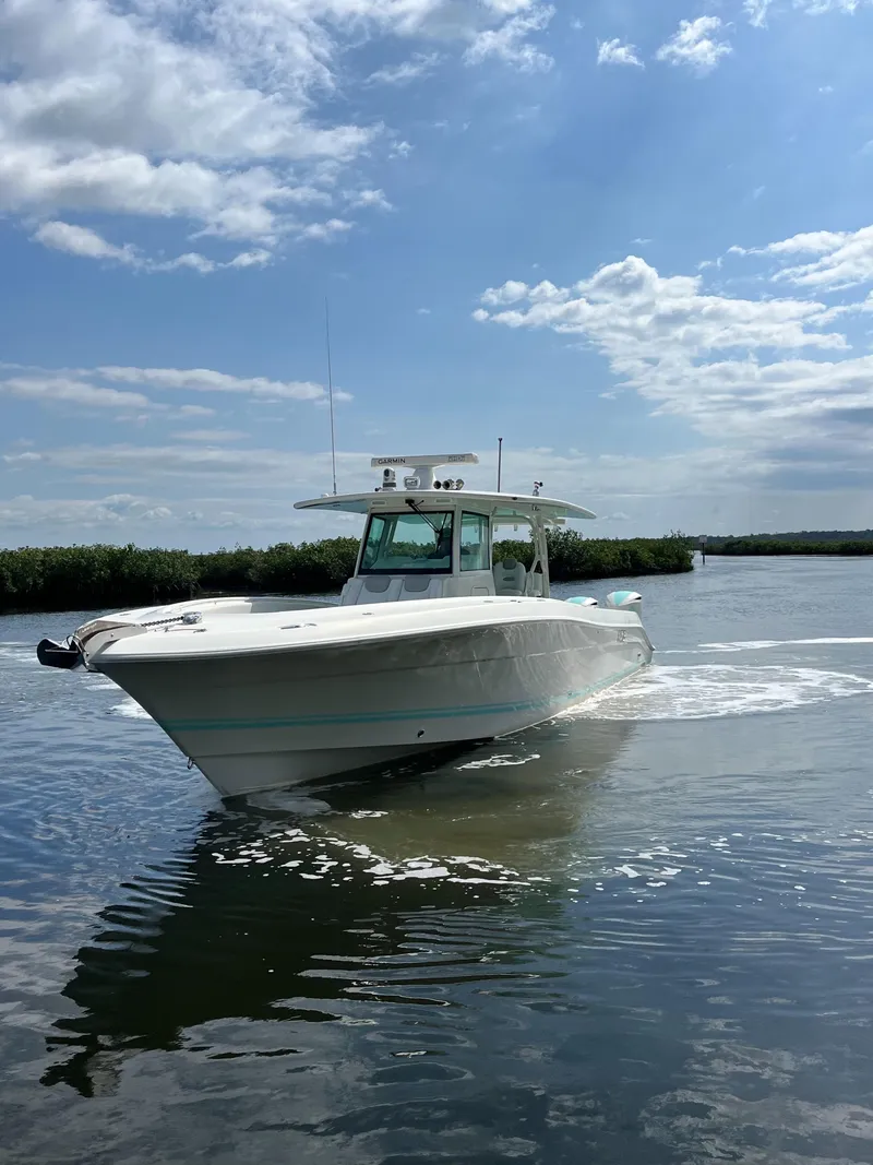 Slide: The Image of 2019 HCB Siesta boat cruising on calm water under a clear blue sky. - 2