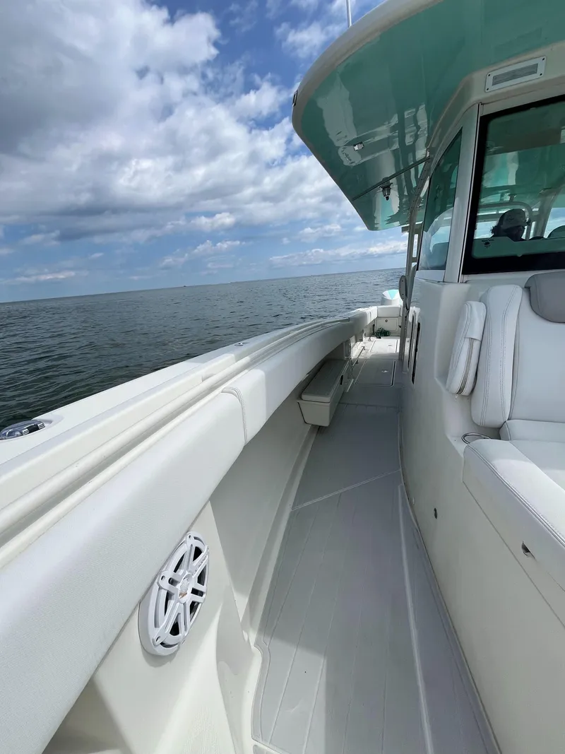 Slide: The Image of 2019 HCB Siesta boat on open water under a partly cloudy sky. - 9