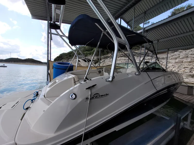 Slide: The Image of 2008 Sea Ray 260 Sundeck boat docked under a canopy on a sunny day. - 2