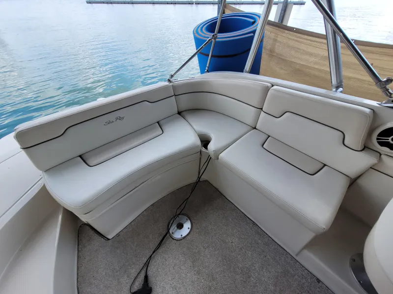 Slide: The Image of 2008 Sea Ray 260 Sundeck interior seating with beige upholstery and lake view. - 6