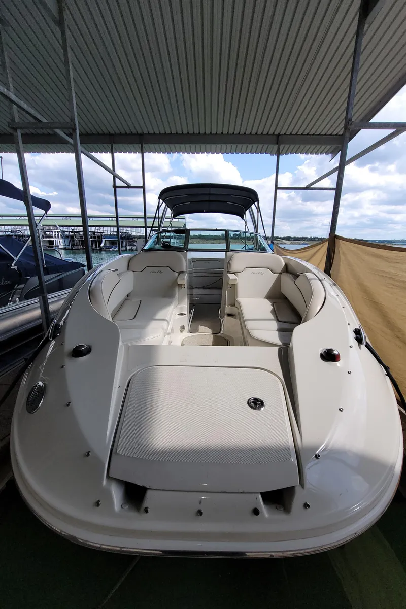 Slide: The Image of 2008 Sea Ray 260 Sundeck boat under covered dock, showcasing spacious seating and sleek design. - 9