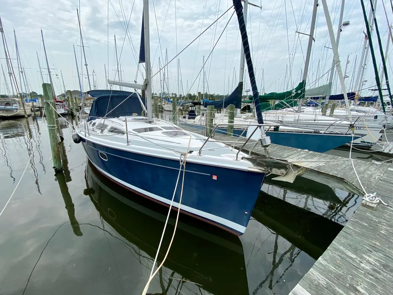 The Image of 2008 Hunter 36-2 sailboat docked at marina, featuring sleek blue hull and white deck. - 1