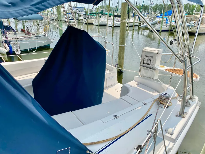 Slide: The Image of 2008 Hunter 36-2 sailboat cockpit with blue cover, docked at marina. - 28