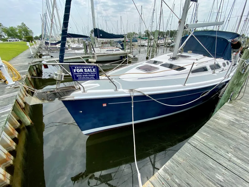 Slide: The Image of 2008 Hunter 36-2 sailboat docked, blue hull, for sale sign visible. - 3