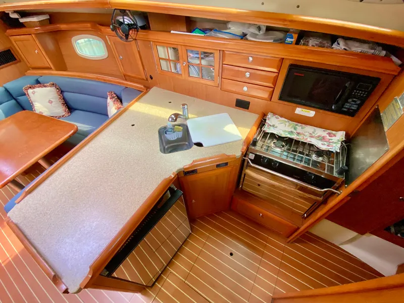 Slide: The Image of 2008 Hunter 36-2 yacht interior with kitchen, dining area, and wooden cabinetry. - 31