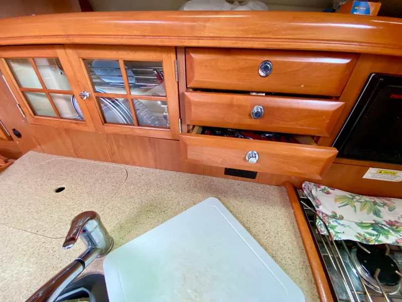 Slide: The Image of 2008 Hunter 36-2 yacht kitchen with wooden cabinets, drawers, and countertop. - 35