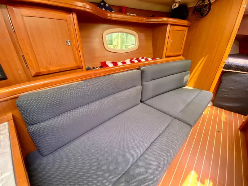 Slide: The Image of Interior of 2008 Hunter 36-2 sailboat with blue cushioned seating and wooden cabinetry. - 38