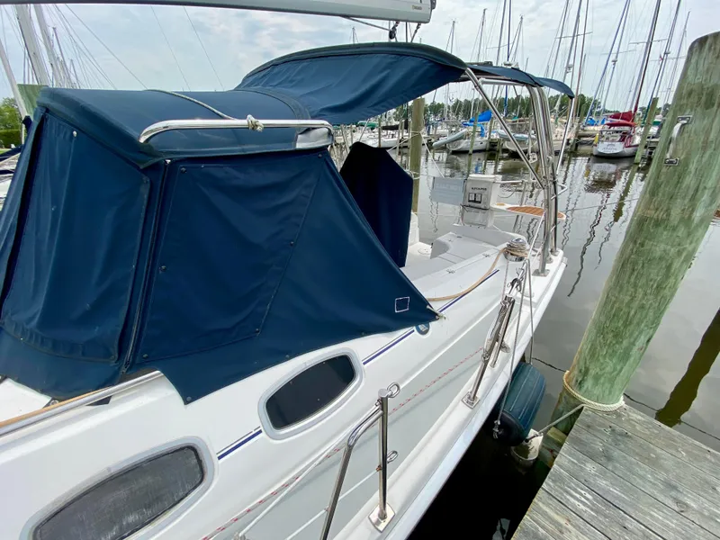 Slide: The Image of 2008 Hunter 36-2 sailboat docked, featuring blue canopy and sleek design. - 4