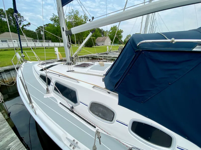Slide: The Image of 2008 Hunter 36-2 sailboat docked, featuring sleek design and blue canopy. - 5