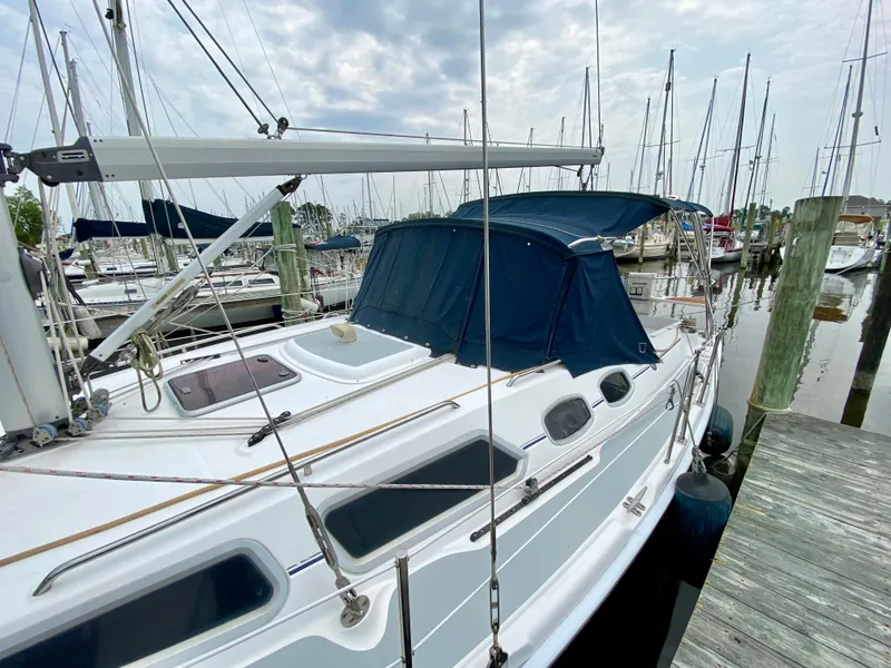 Slide: The Image of 2008 Hunter 36-2 sailboat docked at marina, featuring blue canopy and sleek design. - 7