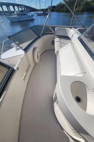 Slide: The Image of 1995 Sea Ray 440 Express Bridge yacht with spacious deck and scenic waterway view. - 12